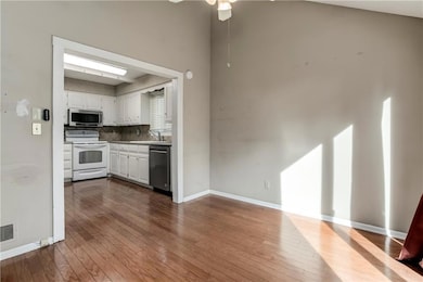 Dining area with hardwood flooring and ceiling fan, adjacent to the kitchen for convenient meal service and gathering space.
