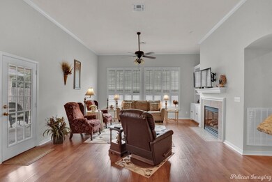 Living room with ornamental molding, wood-type flo