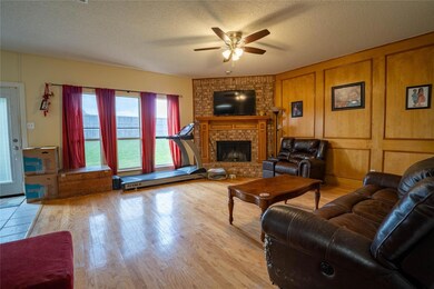 Living room featuring ceiling fan, a fireplace, a 