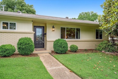 Entrance to property with brick siding, a yard, an
