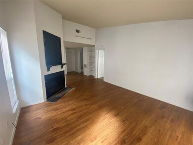 Unfurnished living room featuring wood finished floors and a fireplace with flush hearth