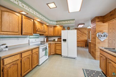 Kitchen featuring wood walls, white appliances, ba
