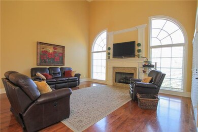 Family room has towering windows and tall ceilings with a fire place creating a center of activity, fun and family environment.