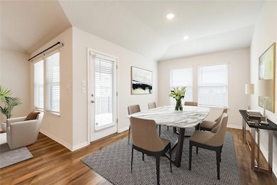 Dining space with dark wood-style flooring, baseb