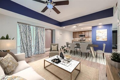Living room featuring ceiling fan and light wood-t