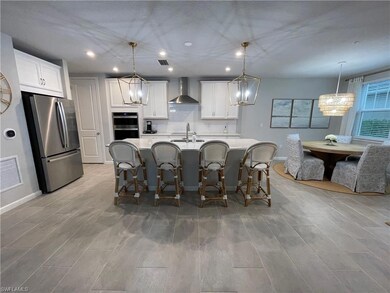 Kitchen featuring wall chimney exhaust hood, white