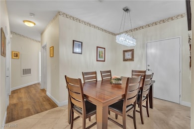 Dining space with light tile patterned floors and a chandelier