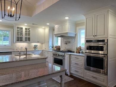 Kitchen with tasteful backsplash, light stone coun