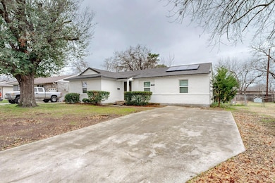 Single story home featuring a front lawn and solar