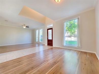 Foyer with light wood-style floors, a ceiling fan