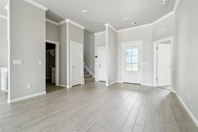 Unfurnished living room with crown molding, light wood-type flooring, and stairs