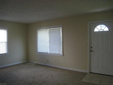 The living room is spacious, airy, filled with nat