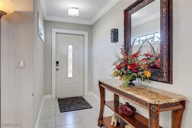 Entryway with baseboards, ornamental molding, and