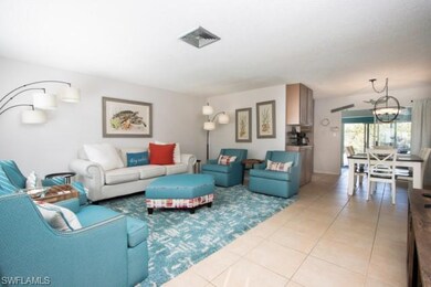 Living area featuring light tile patterned floors and a chandelier