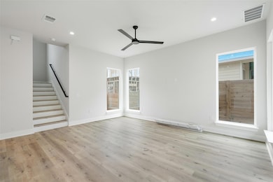 Unfurnished living room featuring ceiling fan, re