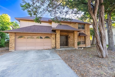 View of front facade featuring a shingled roof, concrete driveway, an attached garage, and brick siding