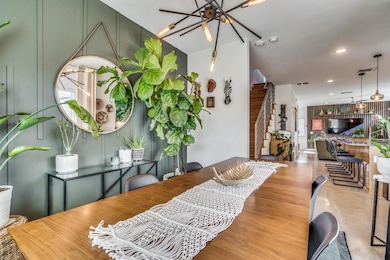 Dining room with visible vents, wood finished flo
