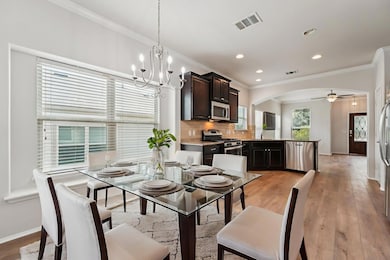 Dining area featuring ornamental molding, baseboards, arched walkways, a ceiling fan, and a chandelier