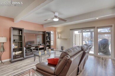 Living room with ceiling fan, LVP flooring and bea