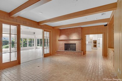 Family room with wood beams, paneling, brick firep