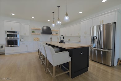 Kitchen with custom range hood, light wood-style f