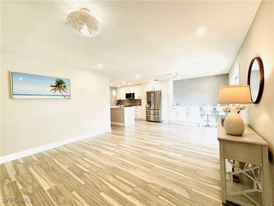 Living area featuring light wood-style tile flooring throughout, recessed lighting