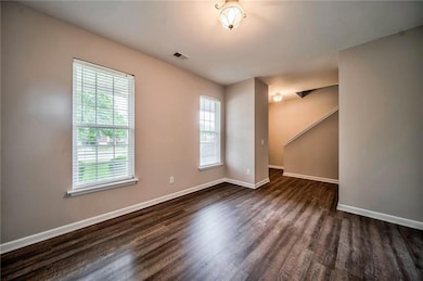 Unfurnished room with plenty of natural light and dark wood-type flooring