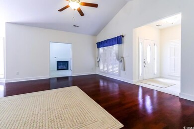 Unfurnished living room featuring a ceiling fan, high vaulted ceiling, a glass covered fireplace, baseboards, and wood finished floors