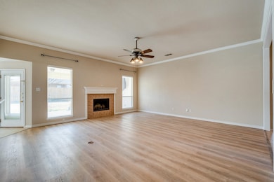 Living room with plenty of natural light, light hardwood / wood-style flooring, and a fireplace