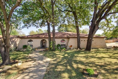 Mature trees shade the pathway and the front porch