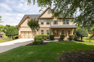 Craftsman inspired home featuring concrete driveway, board and batten siding, a front lawn, and a porch