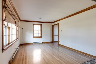 Additional view of the living room. Wide doorway opens into formal dining room.