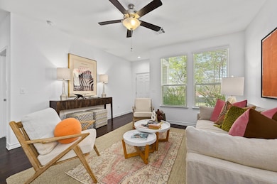 Living area featuring a ceiling fan, wood finishe