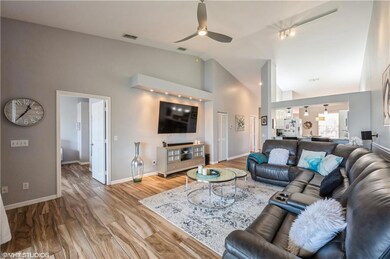 Living room featuring ceiling fan, high vaulted ce