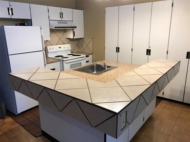 Kitchen featuring white cabinets, a sink, white a
