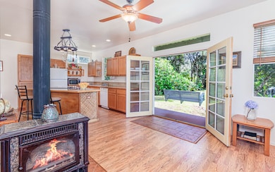 French door entry opens to Great Room. Note skylight window above doorway and porch swing at porch.  So many extra touches in this lovely home.