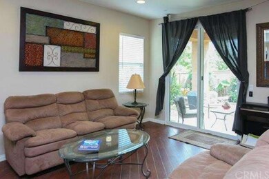 Living room includes cherry laminate flooring and 