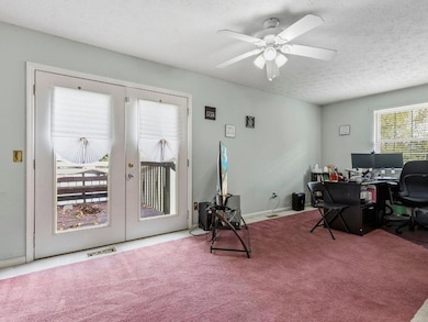 Office area with french doors, carpet floors, a textured ceiling, and a ceiling fan
