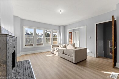 Living area with light wood-type flooring and a brick fireplace