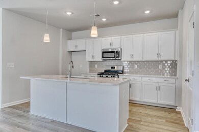Kitchen with hanging light fixtures, white cabinet