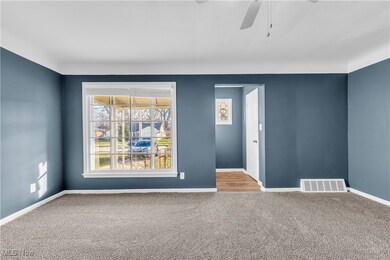 Carpeted spare room featuring ceiling fan