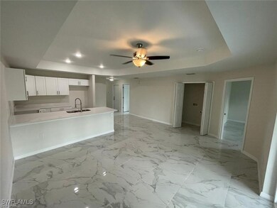 Kitchen with a raised ceiling, a sink, baseboards,