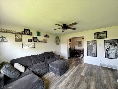 Living room with wood-type flooring, a textured ceiling, and ceiling fan