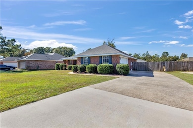 Ranch-style home featuring a front yard and a gara
