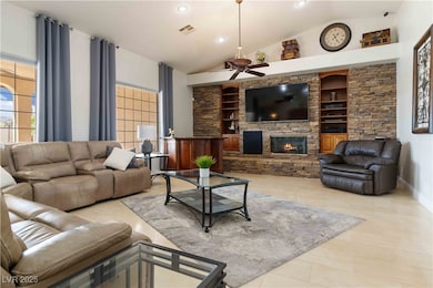 Living room with built in features, a fireplace, light tile patterned floors, recessed lighting, and high vaulted ceiling