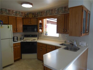 Efficient kitchen has corner sink and pass thru to