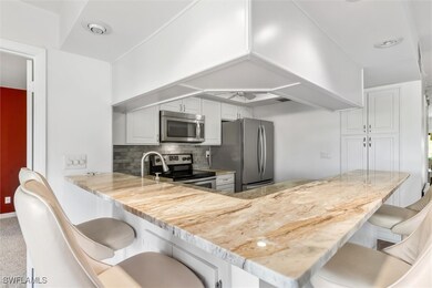 Kitchen featuring a kitchen bar, appliances with s