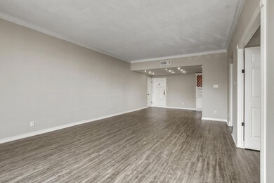 Unfurnished living room with crown molding, dark 