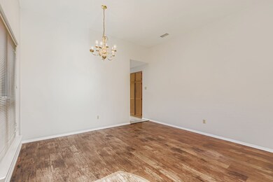 Unfurnished room with wood finished floors and a chandelier