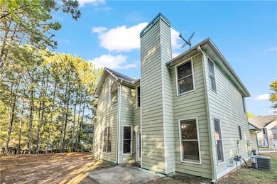 Rear view of property featuring a chimney and a patio